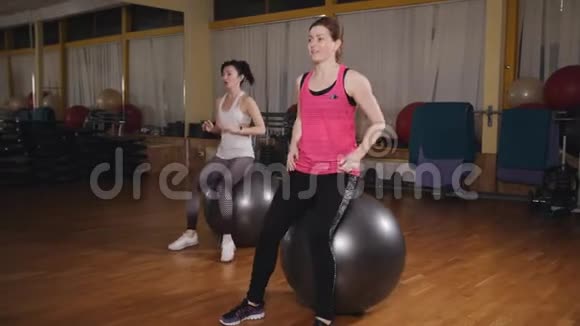 运动妇女在健身室训练健身球视频的预览图
