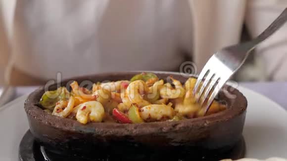 女人正在吃炒热虾与蔬菜在粘土碗特写菜视频的预览图