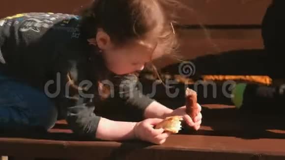 小可爱的女孩和她哥哥在长凳上玩吃面包和香肠视频的预览图