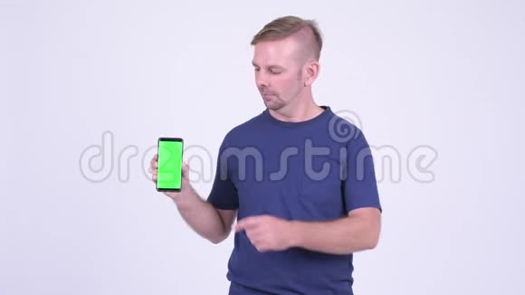 快乐金发男人的肖像展示电话和竖起大拇指视频的预览图