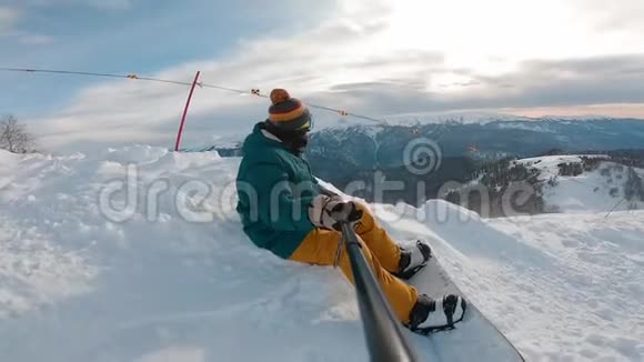 滑雪者坐在山坡边缘的高山上眺望远方视频的预览图