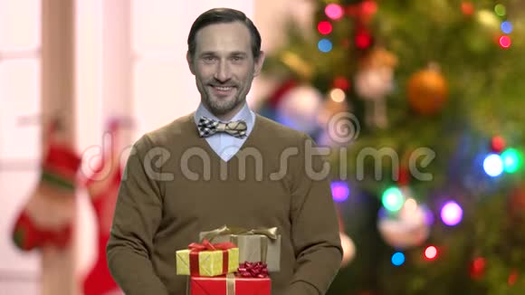 在抽象的圣诞节背景下带礼物的帅哥视频的预览图