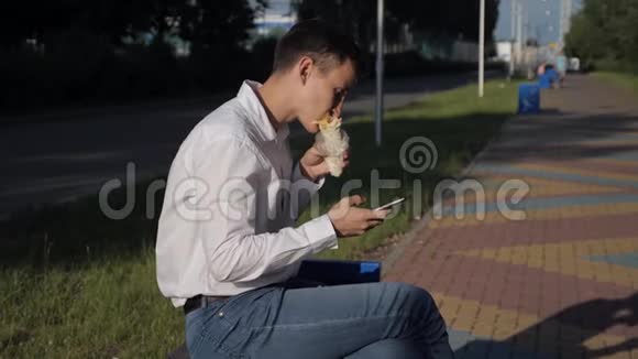 忙碌的男人吃着鞋业在电话里写短信视频的预览图