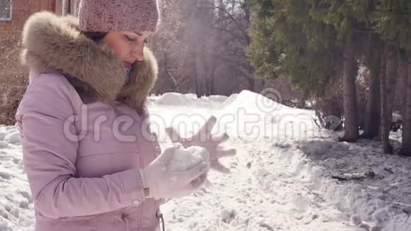 年轻女子用手套雕刻雪球视频的预览图