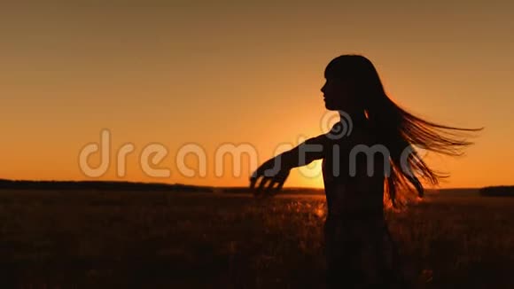 留着长发的女孩在金色的夕阳下飞翔慢动作视频的预览图