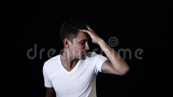 一个穿着白色t恤的英俊短发男人抚摸着他的头发对着镜头说话视频的预览图