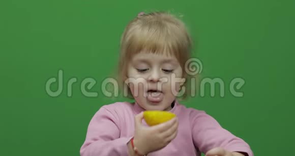 漂亮的年轻女孩吃一个柠檬脸上挂着鬼脸色度键视频的预览图