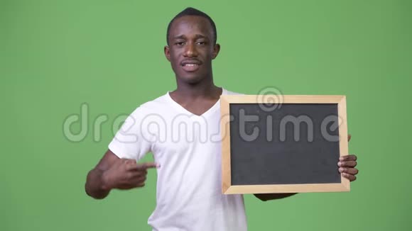 年轻的非洲男子展示黑板并竖起大拇指视频的预览图