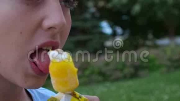 肖像少女吃黄色冰淇淋极端接近视频的预览图