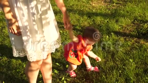 宝贝牵着妈妈的手用绿草把她的草坪撕裂视频的预览图