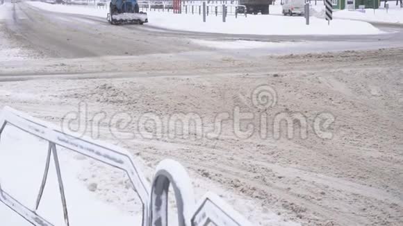 在城市的道路上大雪纷飞冬天城市慢潮拖拉机视频的预览图
