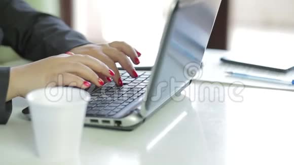女性手在笔记本电脑上做特写喝咖啡动作缓慢视频的预览图
