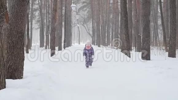 冬天和圣诞节的概念快乐的小女孩在冬天的公园里奔跑视频的预览图
