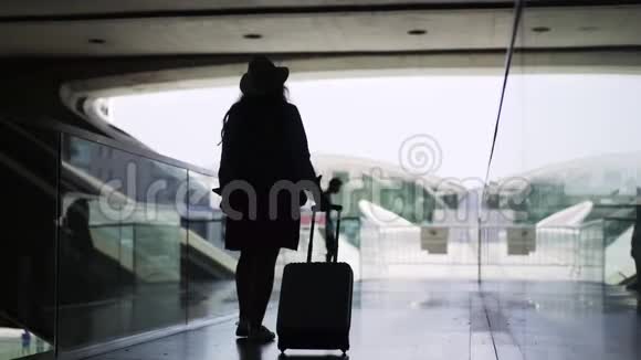 匿名女性带着黑色通道的手提箱视频的预览图