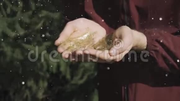一个人用手在大自然的背景下吹出金光视频的预览图