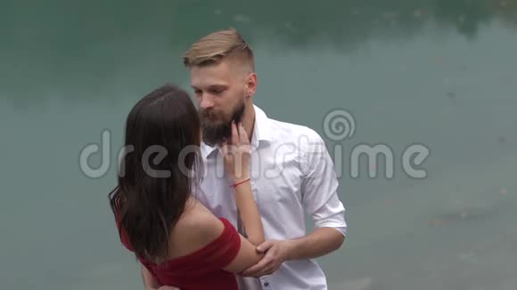 绿松石湖背景下一对恩爱夫妻的柔情视频的预览图