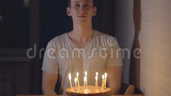 年轻人在节日蛋糕上吹蜡烛视频的预览图