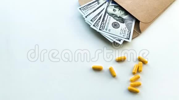 昂贵的药在白色桌子上放不同颜色的钞票视频的预览图