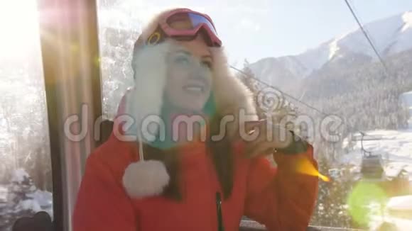 滑雪场女孩乘坐滑雪缆车舱欣赏美丽的白雪覆盖的风景视频的预览图