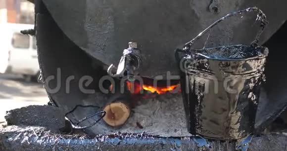 在脏钢桶中煮沸焦油着火4K视频的预览图