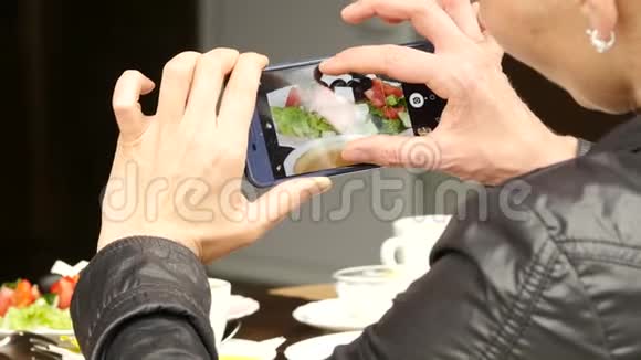 户外咖啡馆的女人拍了一张食物绿色沙拉和一杯咖啡的照片4K视频的预览图