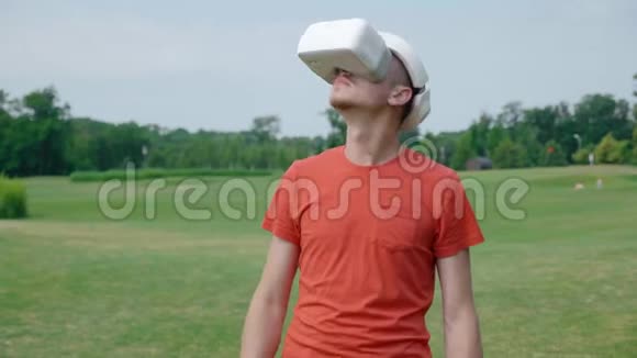 一个男人在公园里用VR耳机环顾四周视频的预览图