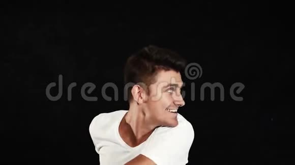 一个穿着白色t恤和裤子的帅哥正微笑着跳舞转身视频的预览图