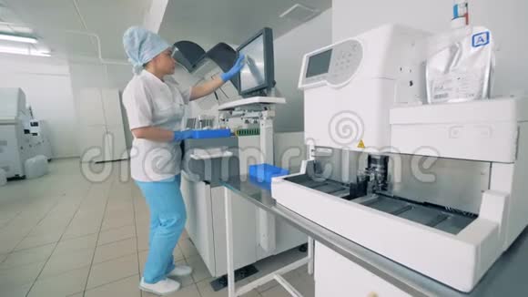 药物实验室工作人员在机器的监视器上打字对血样进行测试视频的预览图