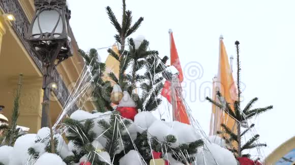 用玩具装饰的圣诞树暴风雪中它站在街上特写镜头视频的预览图