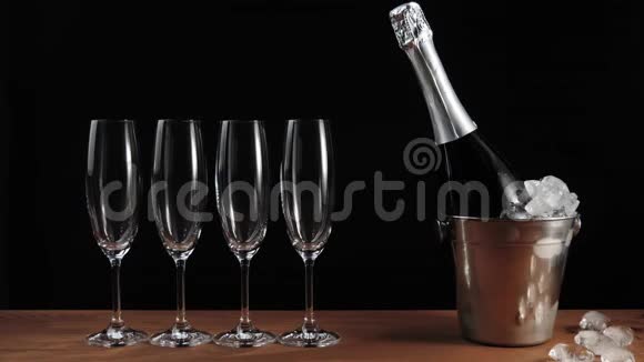 好香槟酒四个空杯子香槟酒立在木桌上背景黑色手拿瓶子视频的预览图