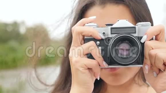 迷人的女孩在复古相机上拍照特写视频的预览图