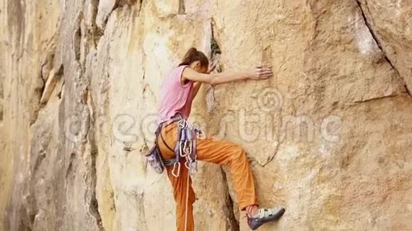 年轻的女性攀岩者试图爬上悬崖寻找伸手和抓住视频的预览图
