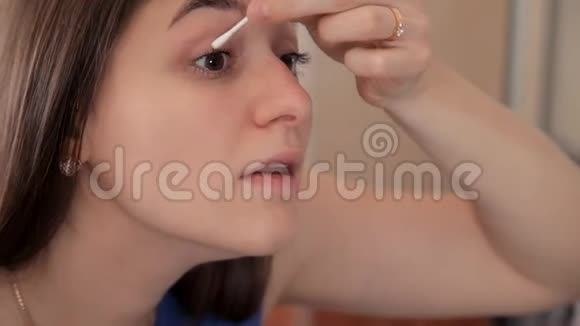 一个年轻的女孩准备一顿浪漫的晚餐用一种特殊的化妆品揉眼睛视频的预览图