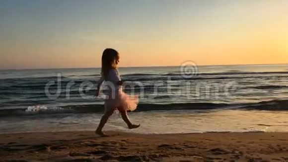 日落时小女孩在海滩上向母亲跑去视频的预览图