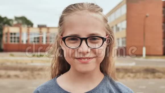 微笑的金发11岁带眼镜的女孩视频的预览图