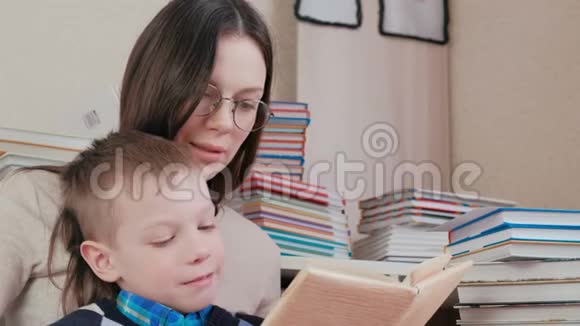 妈妈和儿子一起读一本书妈妈戴着眼镜特写镜头视频的预览图