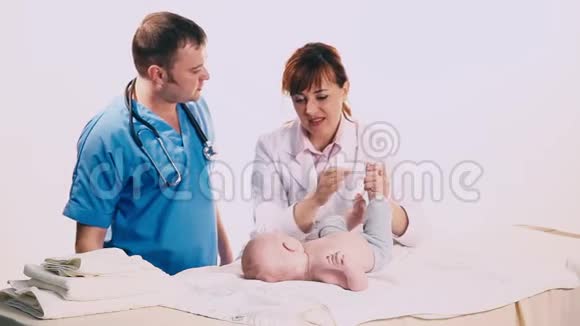 两个医生给一个男婴做检查视频的预览图