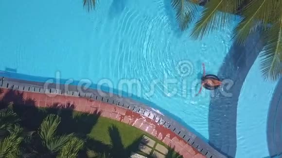 在游泳女孩附近的泳池水上晒太阳视频的预览图