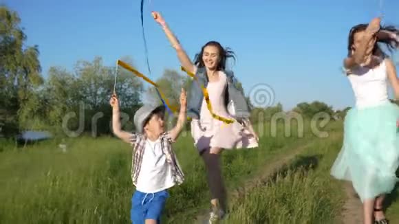 微笑的少女带着彩带挥舞的孩子在户外享受假期视频的预览图