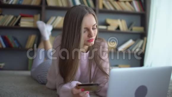 漂亮的少女在家里用信用卡和平板电脑在网上购物4K漂亮少女购物视频的预览图