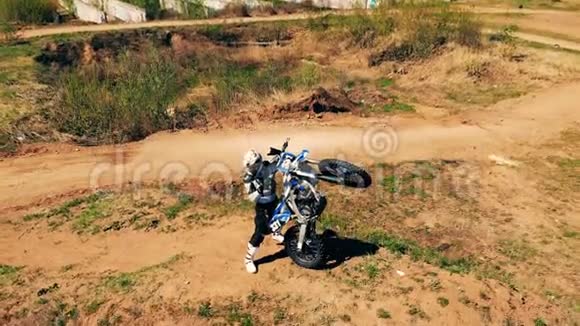 一个骑手站着垂直地拿着他的摩托车视频的预览图