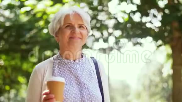 老妇人沿着公园散步喝咖啡视频的预览图