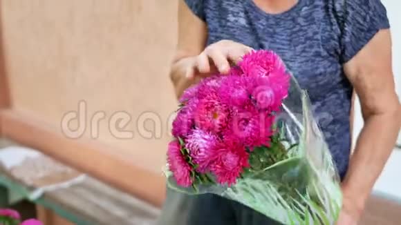 一位老年女性花店老板用米迦勒玛黛西或艾斯特做花束视频的预览图