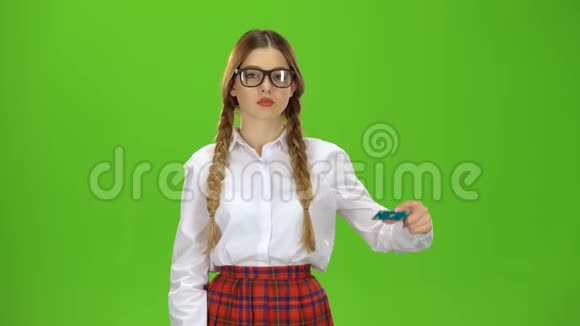 戴眼镜的青少年举起一张卡片显示一个OK绿色屏幕视频的预览图
