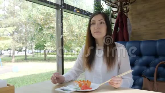 咖啡馆里的年轻女子用木棍吃面包视频的预览图