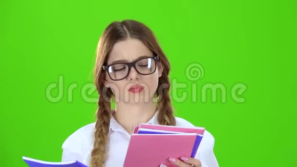 戴眼镜的学生翻过笔记本绿色屏幕视频的预览图