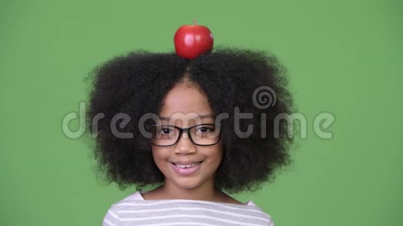 年轻快乐的非洲女孩头上有苹果视频的预览图