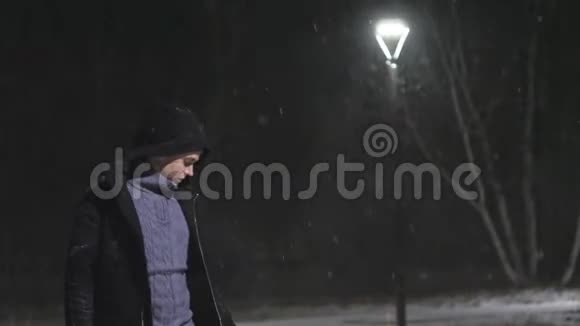 街灯里的那个人在灯的背景下下雪在180fps内缓慢运动雪花真美视频的预览图