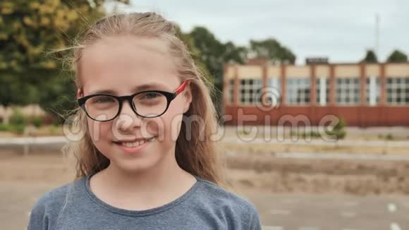 微笑的金发11岁带眼镜的女孩视频的预览图