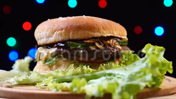凉爽美丽新鲜多汁的熟食汉堡旋转在转盘的背景五颜六色的模糊的灯光视频的预览图